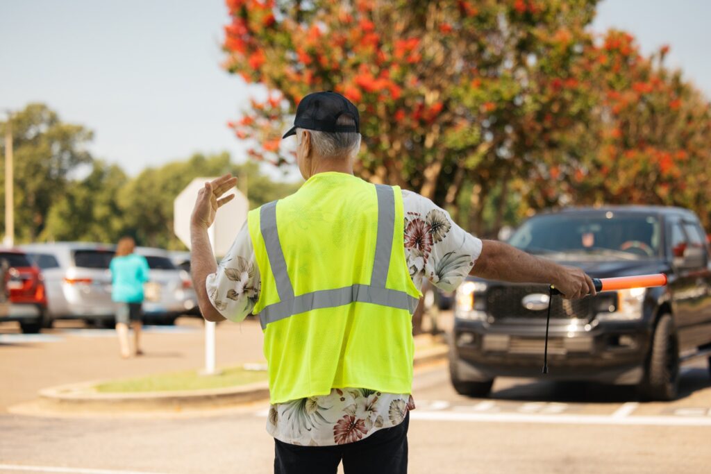 Traffic volunteer directing vehicles in a Bellevue parking lot
